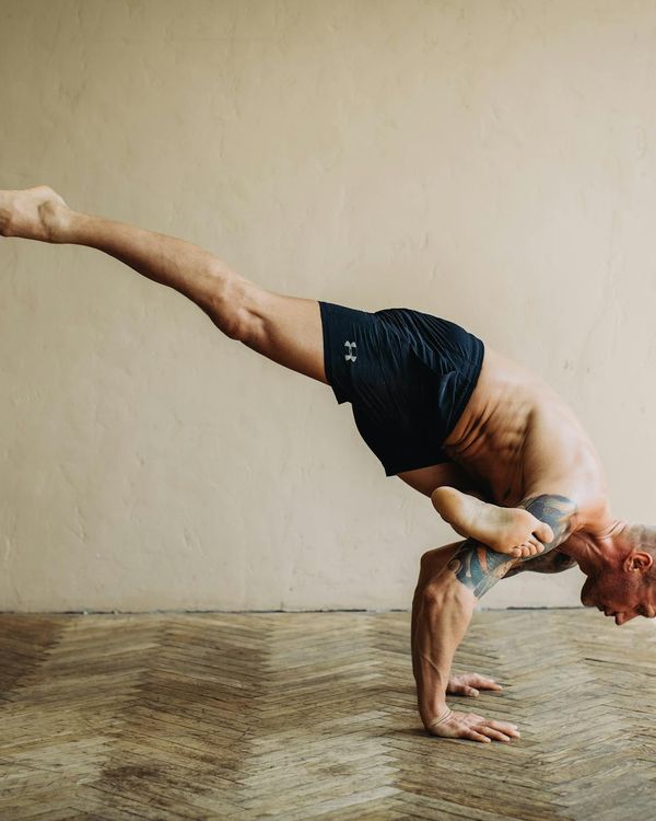 Man in a controlled athletic pose, demonstrating core strength and balance.